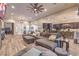 Open living room with a large sectional sofa, wood-look floors and access to the kitchen at 10149 Terrastone Dr, Las Vegas, NV 89148