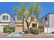 Two-story home with desert landscaping, a garage, and a tree in the front yard at 10162 Sunshine Village Pl, Las Vegas, NV 89183