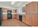 Modern kitchen with stainless steel appliances, wood cabinets, and tile flooring at 10162 Sunshine Village Pl, Las Vegas, NV 89183