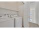 Laundry room featuring a washer, dryer, shelving, and a door at 10162 Sunshine Village Pl, Las Vegas, NV 89183