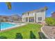 Spacious backyard with a swimming pool, patio, grassy area, and second-story balcony at 1035 Tabor Hill Ave, Henderson, NV 89074