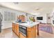 Kitchen island with oven, cooktop, white countertop and wood cabinets at 1035 Tabor Hill Ave, Henderson, NV 89074