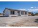 Exterior view of home featuring white siding, dark roof, front door, shutters, gravel front yard, and car port at 1050 Bruce St, Pahrump, NV 89048