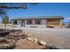 Single-story home with neutral siding, dark trim, wood-look shutters, and arid landscaping at 1050 Bruce St, Pahrump, NV 89048