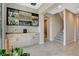 Open-concept dining area with bar, modern gray cabinets, and gray tile flooring near the staircase at 11280 Granite Ridge Dr # 1035, Las Vegas, NV 89135