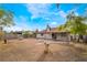 View of a spacious backyard with a covered patio area and mature trees under a blue sky at 1356 Spague St, Henderson, NV 89011