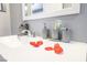 Bathroom counter with sink, silver faucet and bathroom accessories, decorated with red rose petals at 1521 Sombrero Dr, Las Vegas, NV 89169
