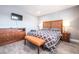 Bedroom showcases modern bed, wood-look floors, TV and an orange bench at 1521 Sombrero Dr, Las Vegas, NV 89169
