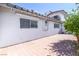 Home's exterior features a brick patio, window bars, and a white stucco exterior under a clear blue sky at 1521 Sombrero Dr, Las Vegas, NV 89169