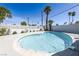 Inviting backyard featuring a sparkling blue pool, white brick perimeter, and lush palm trees against a bright sky at 1521 Sombrero Dr, Las Vegas, NV 89169