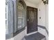 Close-up of a front entry featuring an arched window, textured facade, and a dark security door at 1622 Lorna Dr, Henderson, NV 89011