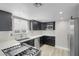 Well-lit kitchen with dark cabinets, stainless steel appliances, and light wood-look floors at 1622 Lorna Dr, Henderson, NV 89011