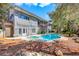 A spacious home exterior, pool, and spa are framed by lush greenery and mature trees in the backyard at 1931 Pago Ct, Las Vegas, NV 89117