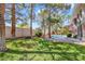 Backyard view features lush green grass with scattered trees leading to a pool area at 1931 Pago Ct, Las Vegas, NV 89117