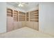 Neutral bedroom with custom built-in shelving and cabinets, plus a ceiling fan and carpeted flooring at 1931 Pago Ct, Las Vegas, NV 89117