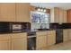 Kitchen with stainless steel appliances, granite countertop and backsplash, and wooden cabinets at 1931 Pago Ct, Las Vegas, NV 89117