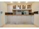 Kitchen bar featuring upper glass door cabinets and granite counters at 1931 Pago Ct, Las Vegas, NV 89117