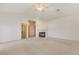 Open-concept living room with neutral carpet, access to a walk-in closet, and a cozy fireplace at 1931 Pago Ct, Las Vegas, NV 89117