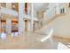 Spacious living room featuring shiny tile flooring and a wooden staircase at 1931 Pago Ct, Las Vegas, NV 89117