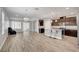 Bright, open-concept living space featuring a kitchen island, chandelier, and wood-style tile floors at 2238 Thelen Ave, North Las Vegas, NV 89086