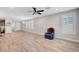 Bright living area featuring wood-look floors, a ceiling fan, and large windows with modern shutters at 2238 Thelen Ave, North Las Vegas, NV 89086