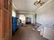 View of the living room needing repair with ladder, peeling ceiling, and wood-paneled walls at 2300 Pardee Pl, Las Vegas, NV 89104