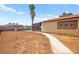 Spacious backyard with a sidewalk and room for landscaping or outdoor activities under a sunny sky at 251 Las Palmaritas Dr, Las Vegas, NV 89110