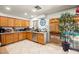 Bright kitchen featuring wooden cabinetry, stainless steel appliances, and access to the patio at 251 Las Palmaritas Dr, Las Vegas, NV 89110