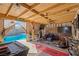 Backyard pool area featuring a covered patio space with comfortable seating and entertainment setup at 251 Las Palmaritas Dr, Las Vegas, NV 89110