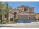 Two-story house with desert landscaping featuring a two car garage and a well maintained lawn at 280 Goldstar St, Henderson, NV 89012