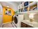 Laundry room with a washer, dryer, and built-in storage shelves at 280 Goldstar St, Henderson, NV 89012