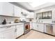 Bright kitchen features white cabinets, stone countertops, stainless steel appliances, and wood-look flooring at 2851 S Valley View Blvd # 1044, Las Vegas, NV 89102