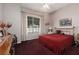 Comfortable bedroom features a red quilt, natural light from a window, and neutral-toned walls at 3522 Shonna Way, North Las Vegas, NV 89032