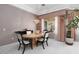 Well lit dining area with an elegant table and chairs under a decorative light fixture with a view to the outside at 3522 Shonna Way, North Las Vegas, NV 89032
