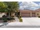Charming single-story home with a three-car garage, tile roof and landscaped front yard with mature tree at 3522 Shonna Way, North Las Vegas, NV 89032