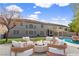A lovely backyard features a firepit with chairs, a pool with rock features, and plenty of green grass at 358 Whispering Tree Ave, Las Vegas, NV 89183