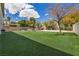 Large backyard with green lawn, patio area, and view of the pool and landscaping at 358 Whispering Tree Ave, Las Vegas, NV 89183