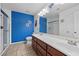 Bathroom featuring blue walls, a shower with glass doors, and a double sink vanity at 358 Whispering Tree Ave, Las Vegas, NV 89183