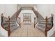 Elegant foyer with curved staircases showcasing decorative iron railings, tile floors, and an open layout at 358 Whispering Tree Ave, Las Vegas, NV 89183