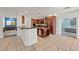 Open kitchen features stainless appliances, granite counters, island with storage, and tiled floor at 358 Whispering Tree Ave, Las Vegas, NV 89183