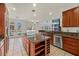 Spacious kitchen featuring an island, stainless appliances, granite countertops, and backyard views at 358 Whispering Tree Ave, Las Vegas, NV 89183