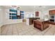 Open kitchen offers granite counters, stainless appliances, tiled floor and seamless flow into living room at 358 Whispering Tree Ave, Las Vegas, NV 89183