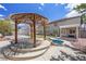 Backyard oasis featuring a pool, spa, and outdoor living area with mature landscaping at 358 Whispering Tree Ave, Las Vegas, NV 89183