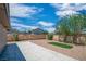 Backyard view with large concrete patio, gravel, privacy fence and mature tree at 416 Rossmoyne Ave, North Las Vegas, NV 89030