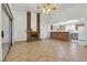 Open living room with tile floors, a brick fireplace, and an open bar area adjacent to the kitchen at 4409 W Red Coach Ave, North Las Vegas, NV 89031