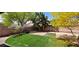 Landscaped backyard featuring artificial turf, desert landscaping, block wall, and mature trees at 4619 Reliant St, North Las Vegas, NV 89031