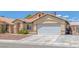 Inviting single-story home with desert landscaping, features a two-car garage and a well-maintained front yard at 4619 Reliant St, North Las Vegas, NV 89031