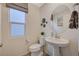 Powder room features decorative round mirror, pedestal sink, and stylish decor at 4977 Birchland Manor Ave, Las Vegas, NV 89139