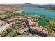 Stunning aerial view of a lakeside resort with lush greenery, palm trees, and red-tiled roofs at 55 Strada Fontana, Henderson, NV 89011