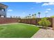 Green backyard with a gravel border, trees, and a brick wall for maximum privacy at 55 Strada Fontana, Henderson, NV 89011